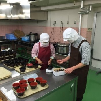 セントラルキッチンでのお弁当盛り付け作業の画像