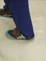 洗浄作業では床が滑りやすいため、靴の上からカバーをかける 安全管理も怠らない
