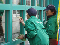 スタッフに窓ガラスの掃除手順を指導する第2号職場適応援助者の指導員